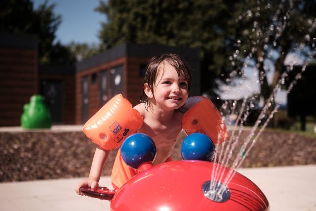 Kind im Freibad mit einem Spritztier